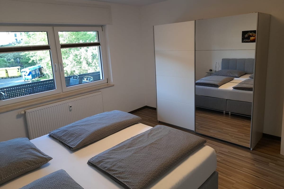 Une chambre à coucher avec un lit, une armoire et une fenêtre.