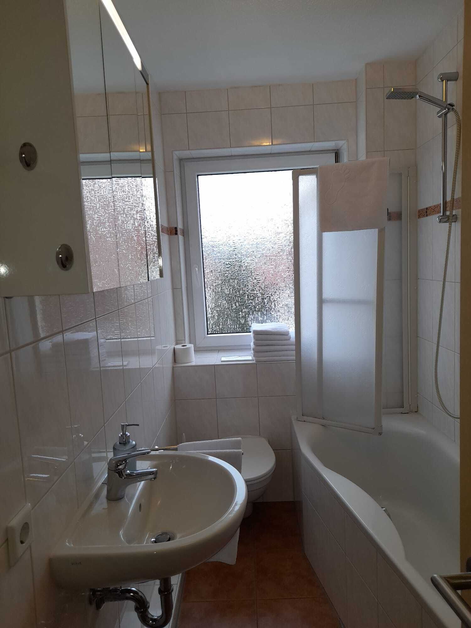 Ein kleines, modernes Badezimmer mit Waschbecken, Toilette und Dusche.