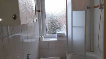 Ein kleines, modernes Badezimmer mit Waschbecken, Toilette und Dusche.