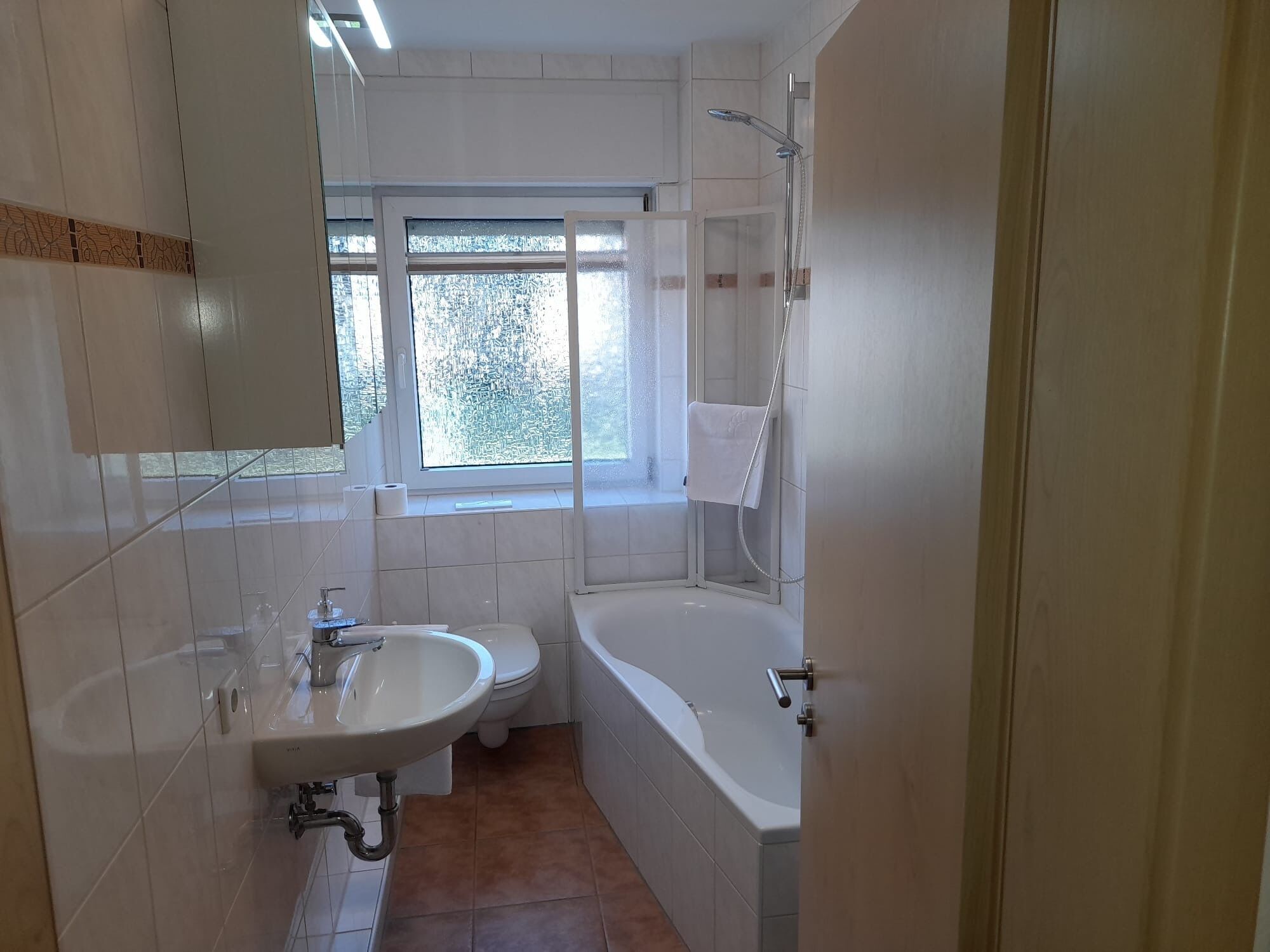A bathroom with a sink, toilet, and bathtub.