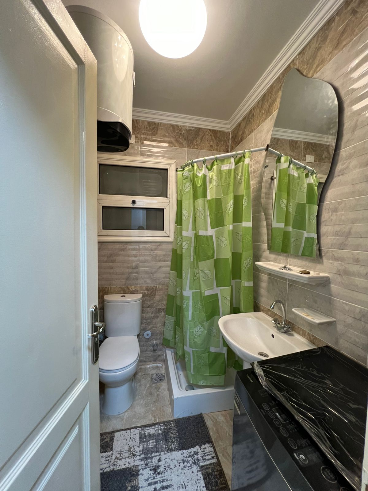 Une salle de bain comprenant des toilettes, un lavabo et un espace douche.