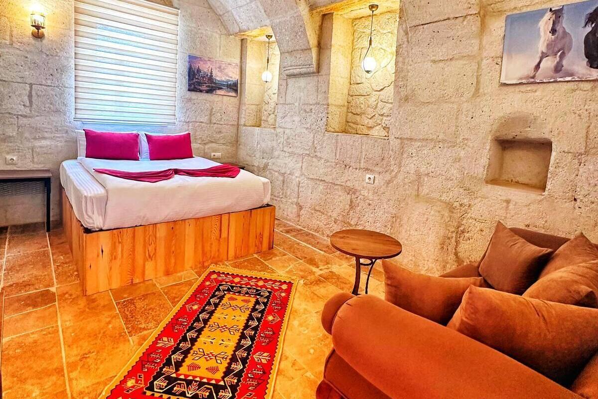 A room with a bed, a sofa, a small table, and a rug.