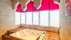 A spa room with a wooden bathtub, stone walls, and a window with red curtains. - CRİMSON CAPPADOCİA (Avanos)