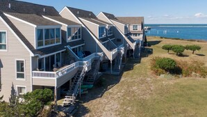 A row of beach houses with balconies, a staircase leading to the beach, and a view of the ocean. - BAY Views/Community Pool - 1 Port Lewes (Lewes)