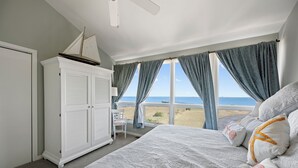 A bedroom with a large bed, a wardrobe, and a view of the beach. - BAY Views/Community Pool - 1 Port Lewes (Lewes)