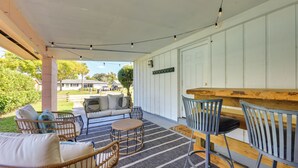 A covered outdoor seating area with wicker chairs and a wooden bar. - 5 Blocks to Jax Beach: Getaway w/ Patio & Yard! (Jacksonville Beach)