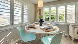 A dining area with a round table, four chairs, and a central light fixture. - 5 Blocks to Jax Beach: Getaway w/ Patio & Yard! (Jacksonville Beach)