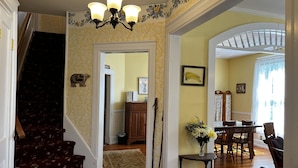 A staircase with floral carpet leading to a dining area with a wooden table and chairs. - Wheelers Inn (Damascus)