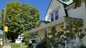 A two-story house with a porch, a large tree, and a sign for 'The Dancing Bear Inn'. - Wheelers Inn (Damascus)