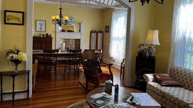 A dining area with a wooden table and chairs, a chandelier, and a fireplace. - Wheelers Inn (Damascus)