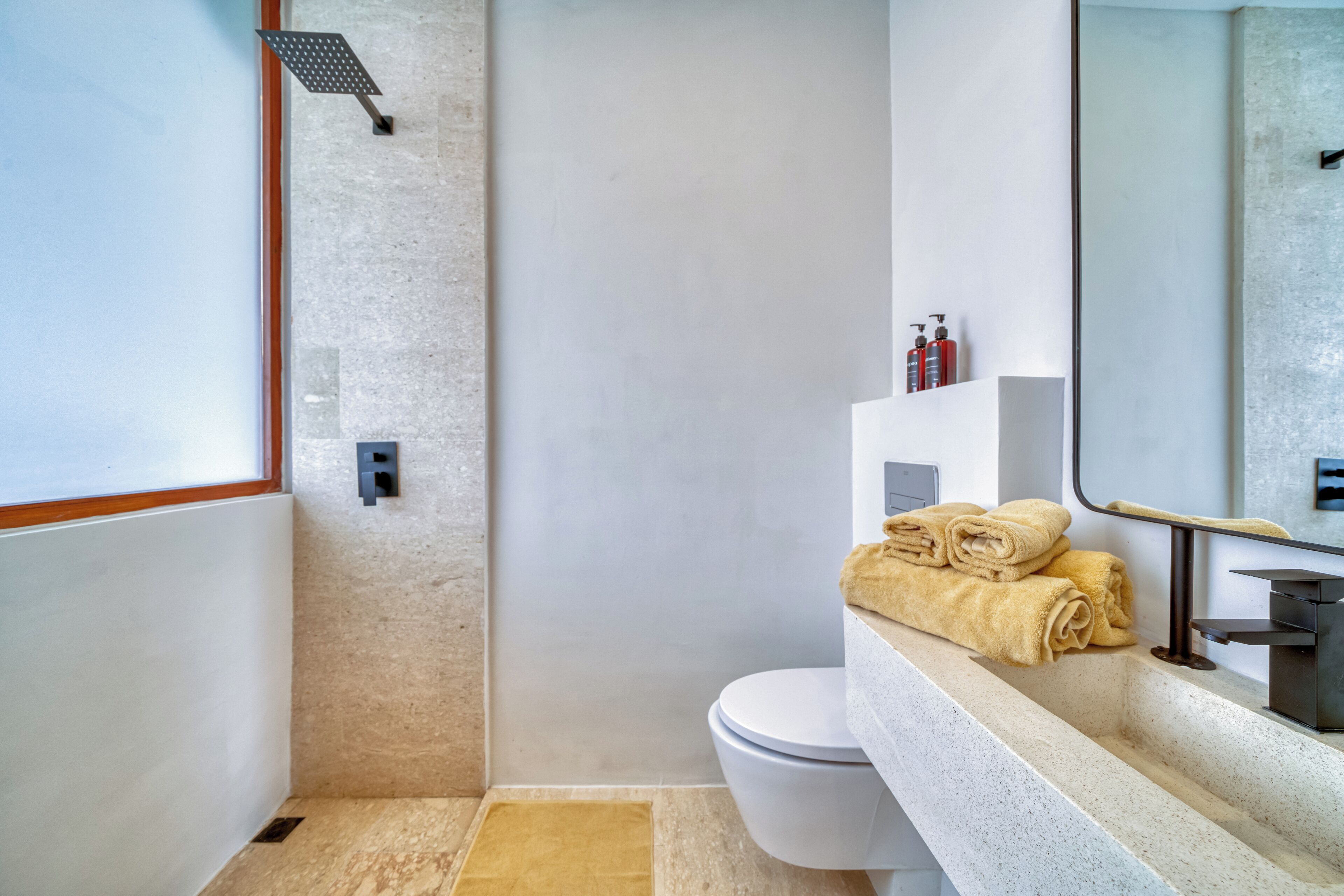 Ein modernes Badezimmer mit Dusche, Toilette und Waschtisch mit Spiegel.