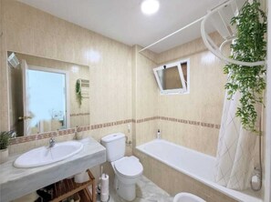 A bathroom with two sinks, a toilet, and a bathtub. - Premium apartment 300 meters from the sea, 5G Wi-Fi, private parking, swimming pool. (Manilva)