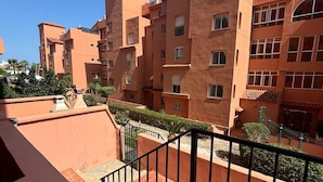 Un edificio residencial de varios pisos con balcones y una escalera.