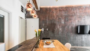 Een moderne keuken met een houten tafel, een schaal fruit en een bloevas.