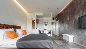 Een moderne hotelkamer met een groot bed, een bureau en een aan de muur bevestigde televisie.