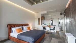 Een moderne hotelkamer met een groot bed, een bureau en een kitchenette.
