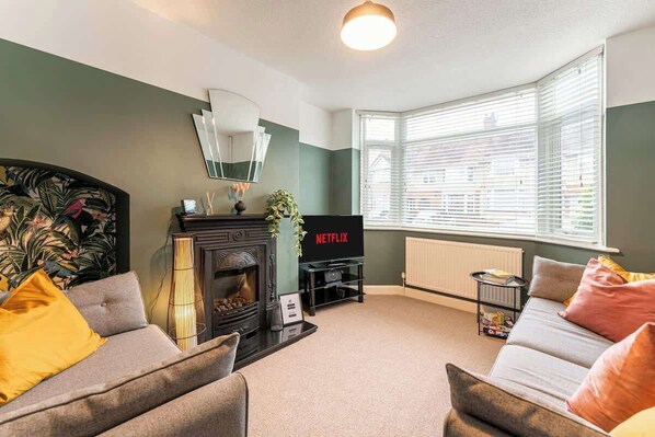 A living room with a fireplace, sofa, and a television. - Spacious 3bed with Free Parking Near NEC&BHX Airport (Coventry)