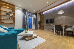 A modern living room with a sofa, coffee table, and dining area.