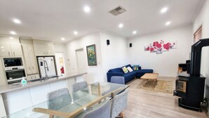 Un espace de vie moderne comprenant une cuisine, un coin repas et un salon confortable.