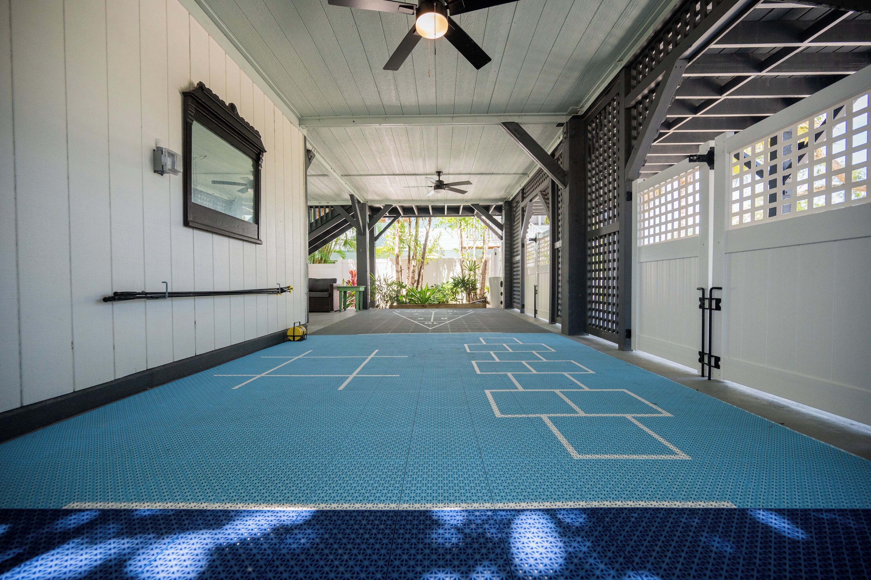 A room with a blue carpet, white walls, a ceiling fan, and a window.