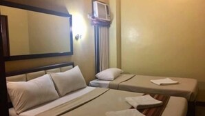 A hotel room with two single beds, a bedside table, an air conditioning unit, and a mirror on the wall. - WJV Mia Hotel Humay-Humay (Lapu-Lapu)