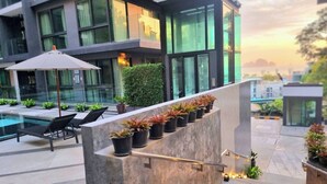 A modern outdoor seating area with a pool, potted plants, and a staircase leading to a rooftop terrace. - A204 - 1 Bdr Condo With Sea View, Ao Nang Beach (Krabi)