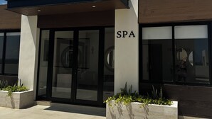 A modern spa building with a glass entrance, a sign reading "SPA", and a covered outdoor area with planters. - “Elegant 3-Bedroom Apartment with Stunning Views in Cancun (Cancun)