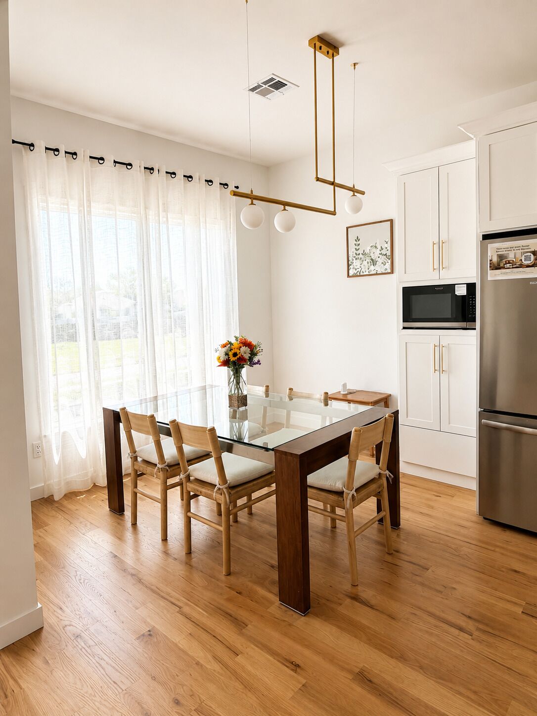 Een moderne keuken met een eettafel, stoelen en een koelkast.
