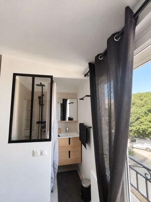 A modern bathroom with a shower, a mirror, and a sink. - Charming 2-bedroom duplex, tram and free parking (Saint-Jean-de-Védas)