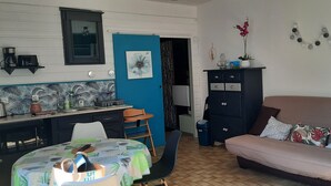 Una habitación con una mesa de comedor, sillas, un sofá, un armario y una puerta.