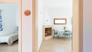 Una habitación con una cama, una pequeña mesa con sillas, una chimenea y una ventana.