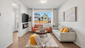 Uma sala de estar moderna com dois sofás, uma mesa de centro e uma televisão.
