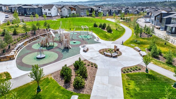 Zona residencial com casas modernas, um parquinho e um parque ajardinado.