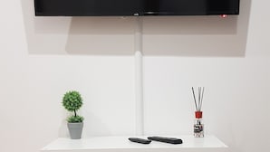 A white TV stand with a flat-screen TV mounted above it.