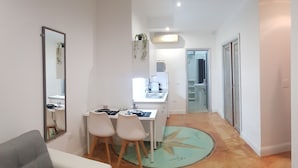 A modern kitchen with a dining area, a mirror, and a small table with chairs.