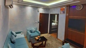 A modern living room with a sofa set, a coffee table, and a small dining area. - Neroz Inn Furnished Apartments (Jeddah)