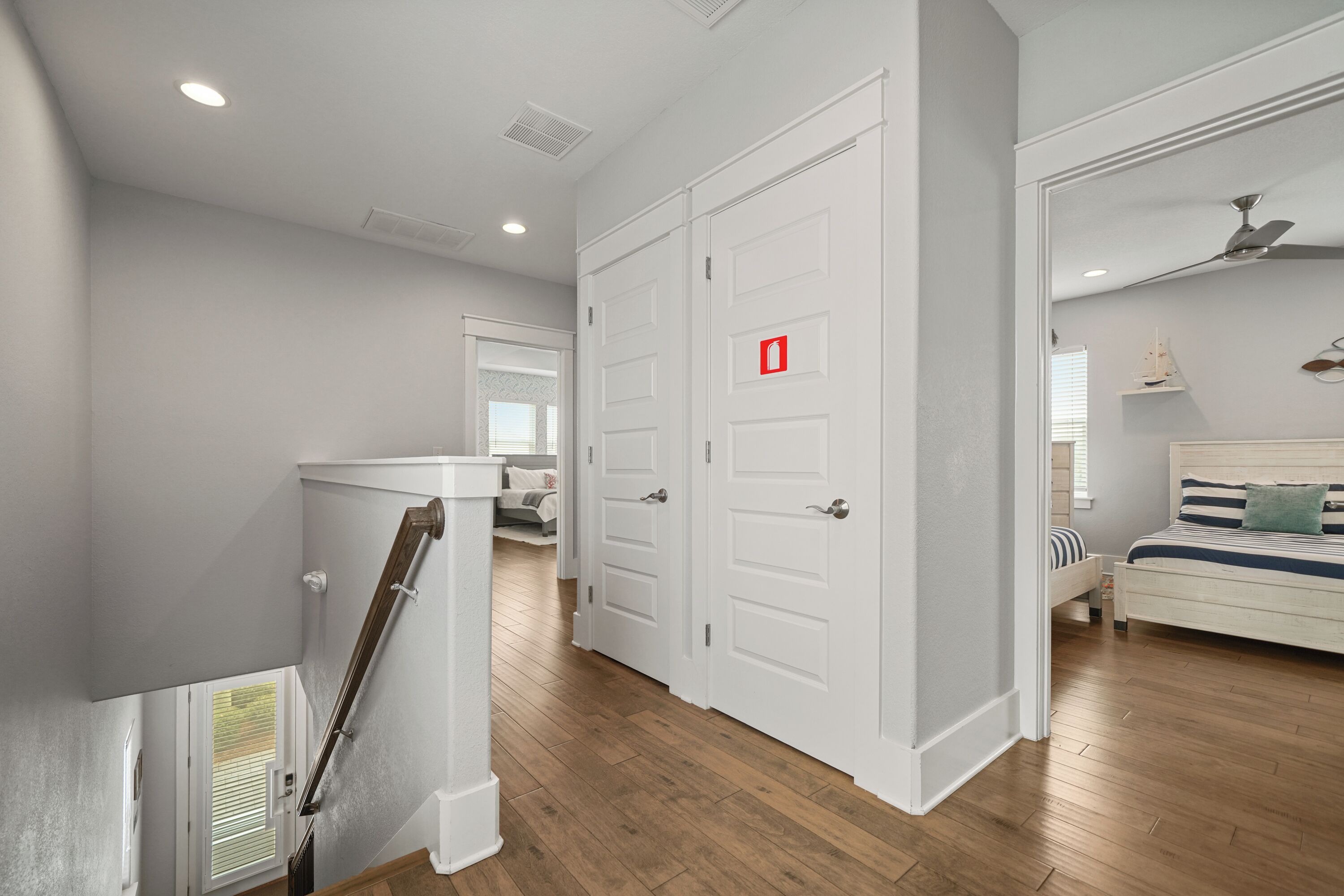 A bedroom with a bed, a nightstand, a dresser, and a ceiling fan.