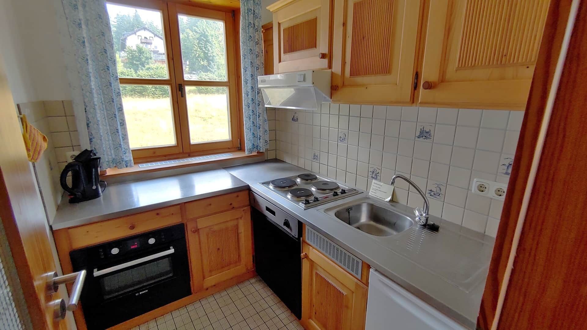 A compact kitchen with a Bosch oven, a dishwasher, a stove, and a sink.