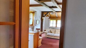A hallway leading to a living area with a wooden ceiling, a sofa, and a dining table. - Holiday apartment "Hoellfelsen" – 2 Guests (Warmensteinach)