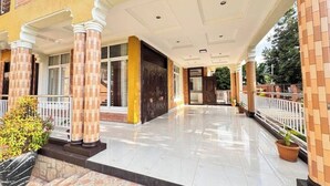 A hotel entrance with a covered walkway, columns, and a tiled floor. - Mu Rugo by Iwacu Stays (Kigali)