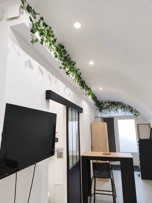 Une cuisine moderne équipée d’un téléviseur à écran plat, d’une table en bois et d’une chaise.