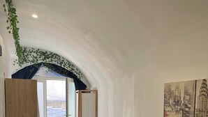 A modern room with a wooden desk, two black chairs, a large window, and a cityscape painting. - Pleasant studio in the heart of town. Close to the A9 and tramway! (Saint-Jean-de-Védas)
