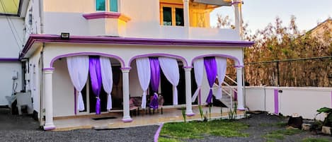 A two-story building with a covered porch area.