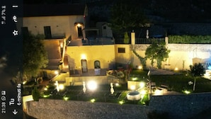 Um pátio com piscina, iluminação externa e uma escadaria que leva a um edifício.
