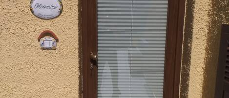A door with a sign above it and a welcome mat in front.