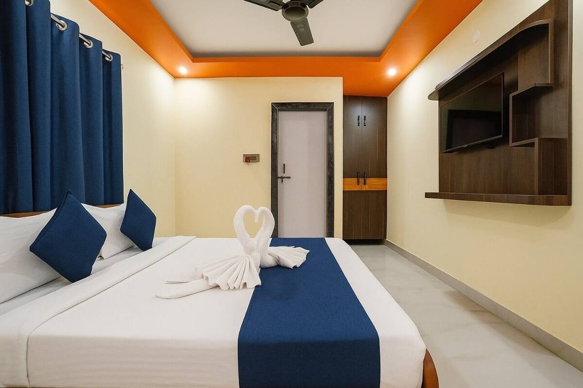 Ein Hotelzimmer mit einem Bett, einem an der Wand montierten Fernseher und einer Tür mit Griff.