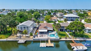 A residential area with a dock, a swimming pool, and houses with a view of the water. - Hernando Beach Gulf Access, Dock & Heated Pool (Hernando Beach)