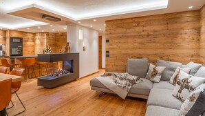 Un salon moderne avec une cheminée, des murs en bois et un canapé agrémenté de coussins décoratifs.