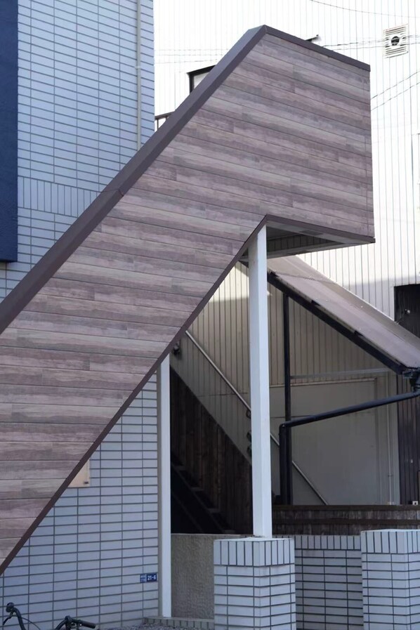 A modern building with a unique staircase design, featuring a combination of wooden and metal elements. - SHIZUKURIA MINAMIGYOTOKU (Ichikawa)