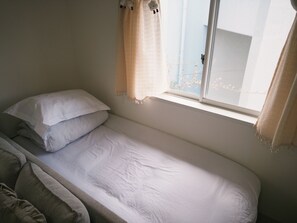 A small, single-bed room with a window and a view of the outside. - SHIZUKURIA MINAMIGYOTOKU (Ichikawa)